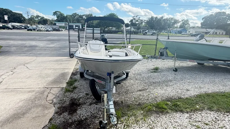 Slide: The Image of A 2027 Boston Whaler 130 Super Sport on a trailer in a parking area. - 1
