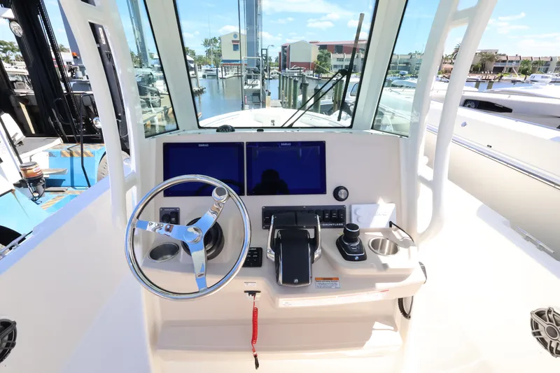 Slide: The Image of The image shows the helm of a Boston Whaler 280 Dauntless with dual screens and a steering wheel. - 25
