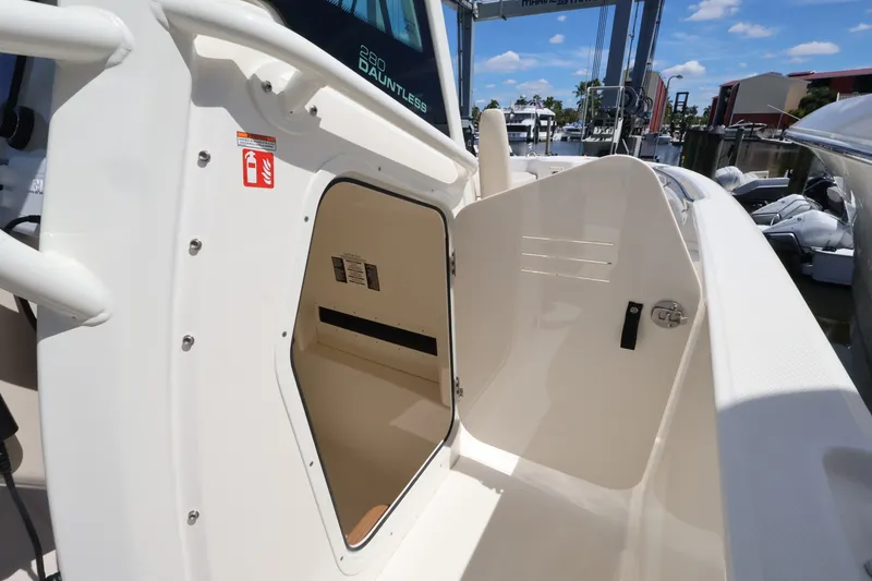 Slide: The Image of The 2027 Boston Whaler 280 Dauntless features an open storage compartment door with a spacious interior. - 12