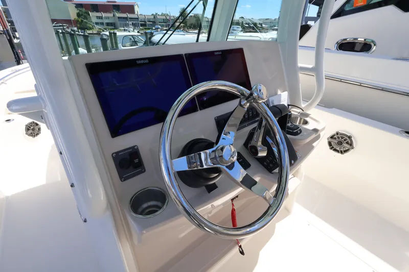 Slide: The Image of The image shows the helm of a Boston Whaler 280 Dauntless with dual screens and a shiny steering wheel. - 24