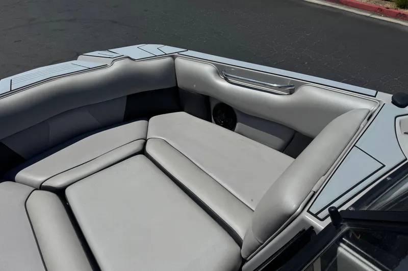 Slide: The Image of 2022 Moomba Max boat interior with gray cushioned seating and sleek design. - 12