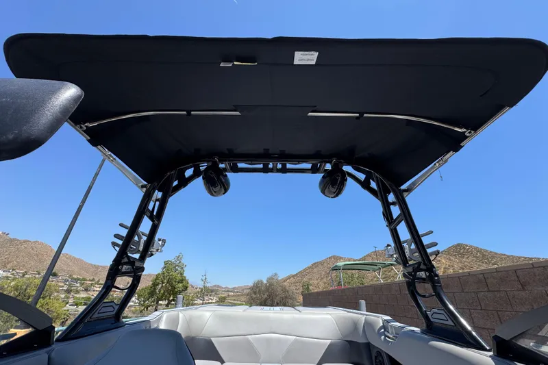 Slide: The Image of 2022 Moomba Max boat interior with canopy, speakers, and scenic mountain backdrop. - 13