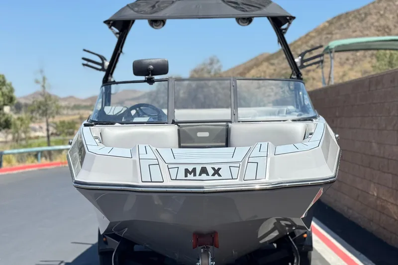 Slide: The Image of 2022 Moomba Max boat parked on a sunny day, showcasing sleek design and modern features. - 2