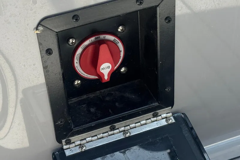 Slide: The Image of Battery switch on a 2022 Moomba Max boat, featuring a red dial and black casing. - 24