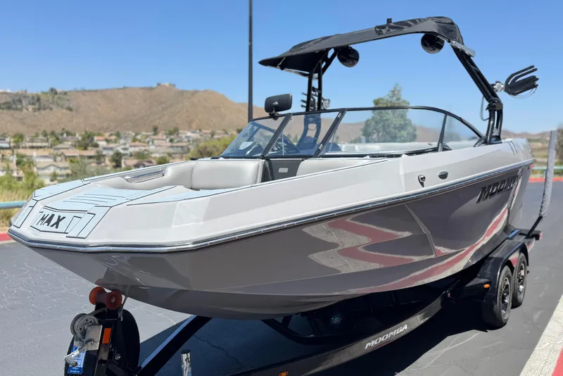 Slide: The Image of 2022 Moomba Max boat on trailer, sleek design, parked outdoors with scenic background. - 3