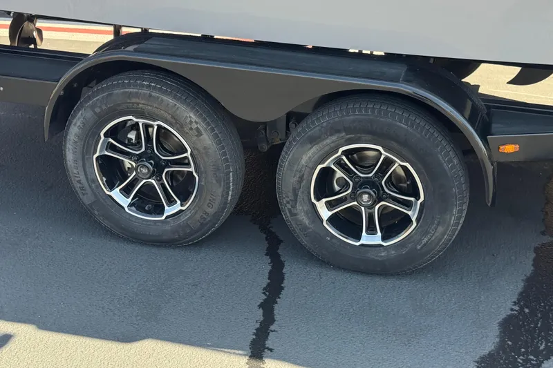 Slide: The Image of 2022 Moomba Max trailer wheels on asphalt, featuring stylish black and silver rims. - 32