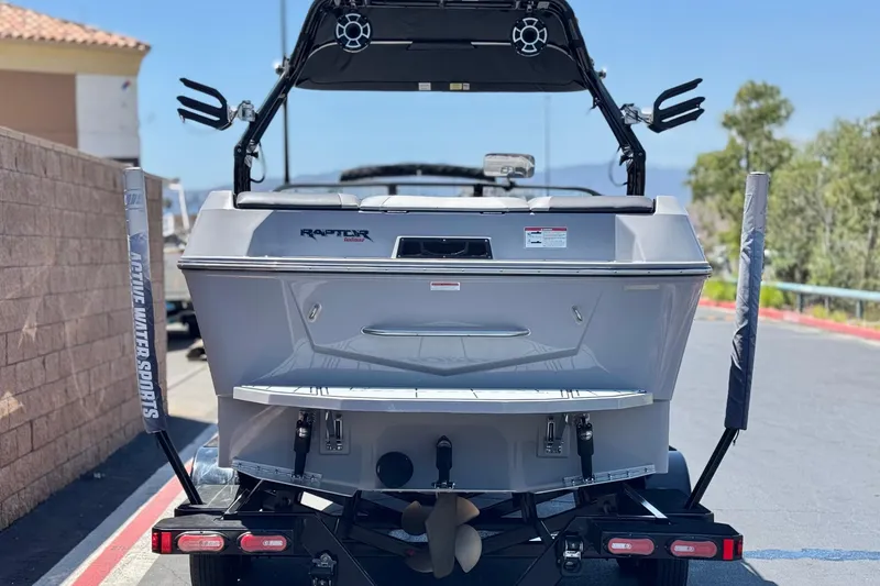 Slide: The Image of 2022 Moomba Max boat rear view with Raptor engine, parked on trailer. - 4