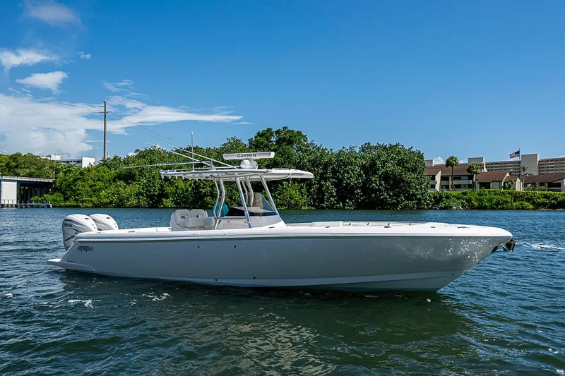 The Image of 2020 Intrepid 345 Nomad FE boat on calm water, clear sky background. - 0
