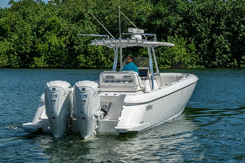 Slide: The Image of 2020 Intrepid 345 Nomad FE boat cruising on a calm lake with twin engines. - 13