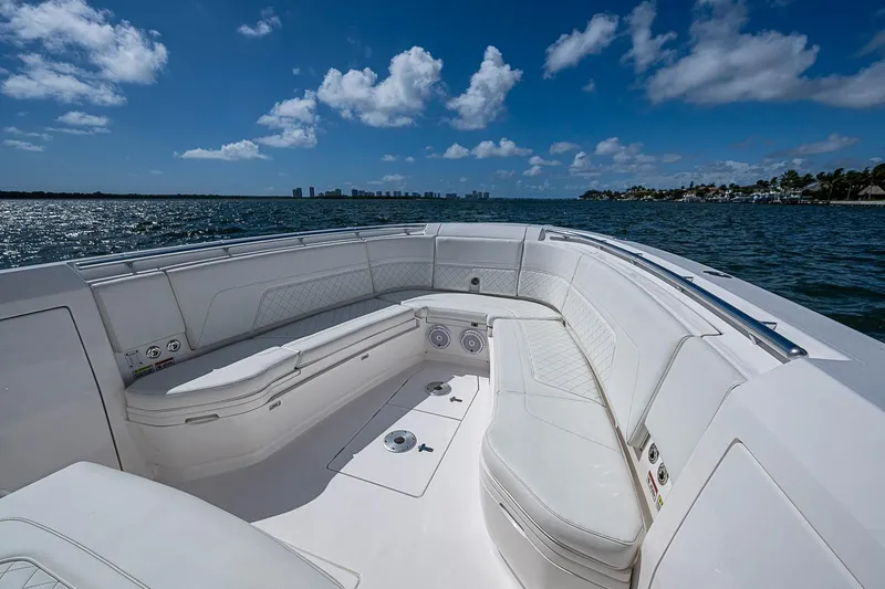 Slide: The Image of 2020 Intrepid 345 Nomad FE boat interior with white seating, ocean view, and blue sky. - 25