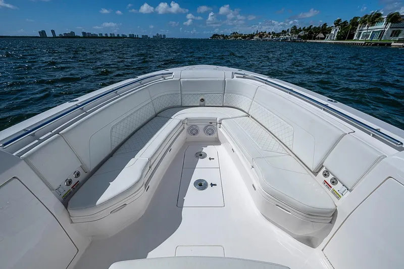 Slide: The Image of 2020 Intrepid 345 Nomad FE boat interior with white seating, on a sunny day at sea. - 26