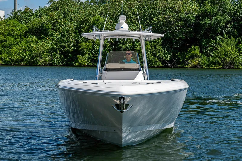 Slide: The Image of 2020 Intrepid 345 Nomad FE boat cruising on a calm river with lush greenery. - 3