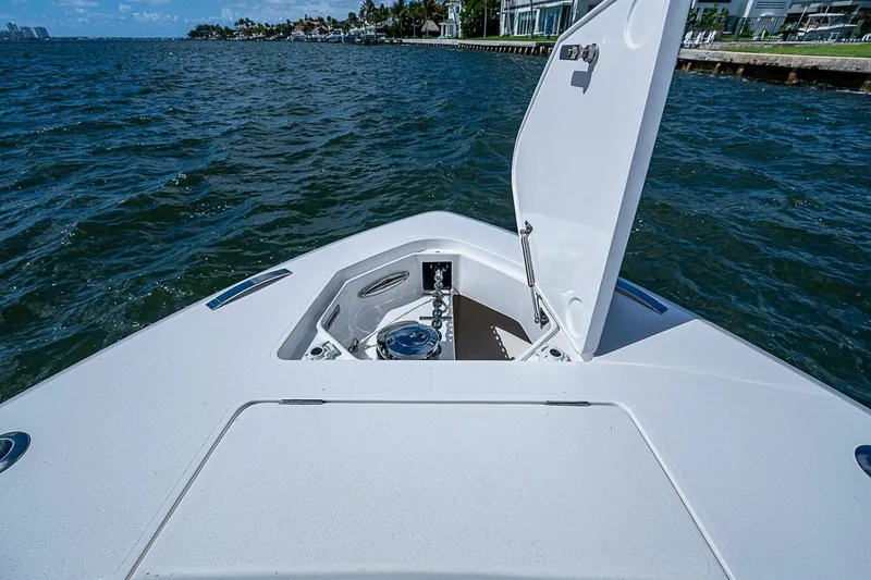 Slide: The Image of Bow view of 2020 Intrepid 345 Nomad FE boat on water, open hatch visible. - 34