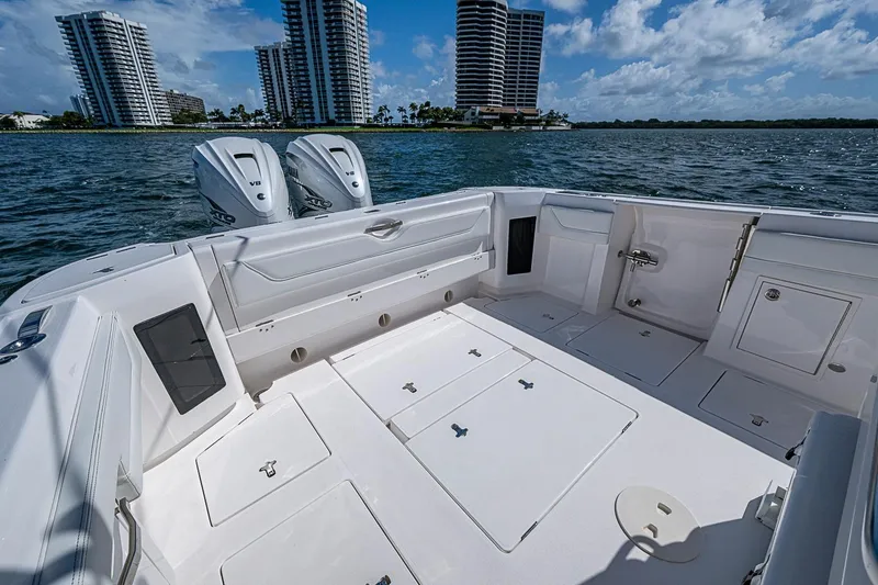 Slide: The Image of 2020 Intrepid 345 Nomad FE boat deck with twin engines, city skyline in background. - 41