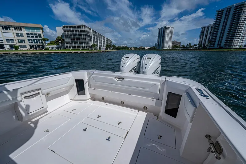 Slide: The Image of 2020 Intrepid 345 Nomad FE boat on water, cityscape background, clear sky. - 42