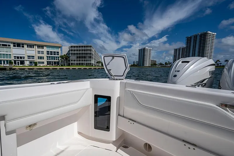 Slide: The Image of 2020 Intrepid 345 Nomad FE boat with Yamaha engines, cruising near waterfront buildings. - 46