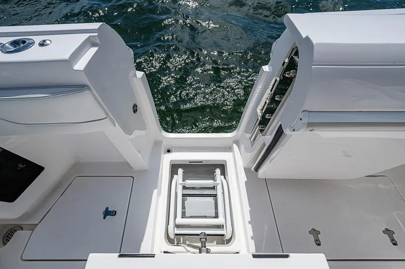 Slide: The Image of 2020 Intrepid 345 Nomad FE boat deck with open hatch and ladder, near water. - 48
