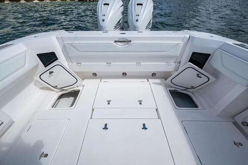 Slide: The Image of 2020 Intrepid 345 Nomad FE boat deck with storage compartments and twin V8 engines. - 51