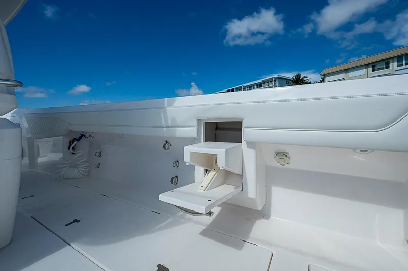 Slide: The Image of 2020 Intrepid 345 Nomad FE boat deck with storage compartment under clear blue sky. - 53