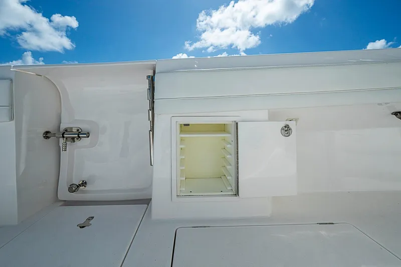 Slide: The Image of 2020 Intrepid 345 Nomad FE boat interior with open storage compartment under blue sky. - 54