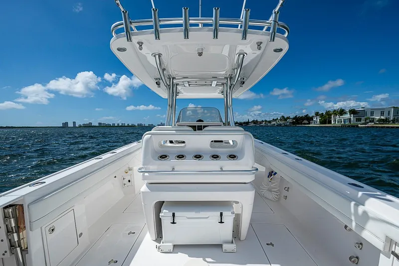 Slide: The Image of 2020 Intrepid 345 Nomad FE boat on open water, clear sky, luxury coastal view. - 56