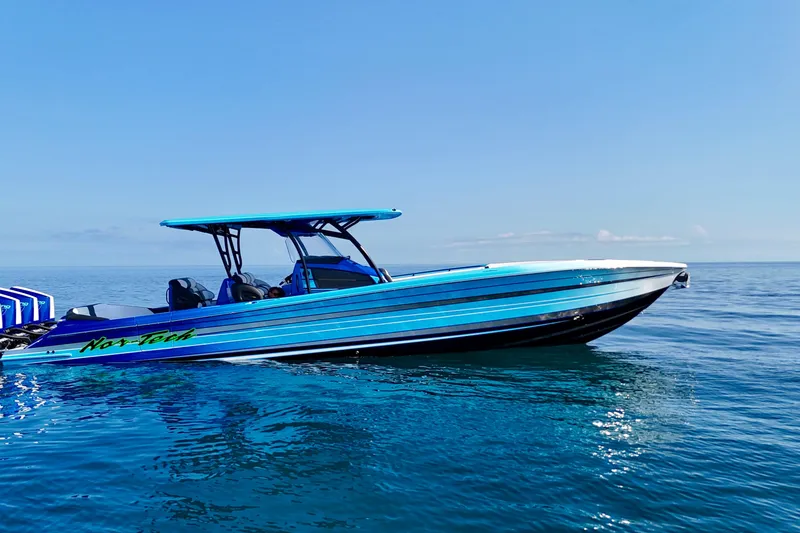 The Image of 2026 Nor-Tech 390 Sport Center Console boat on calm ocean waters under clear blue sky. - 1
