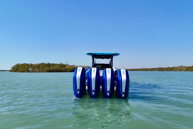 Slide: The Image of 2026 Nor-Tech 390 Sport Center Console with quad engines on calm water. - 12