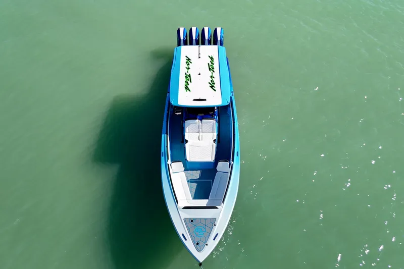 Slide: The Image of 2026 Nor-Tech 390 Sport Center Console boat on calm green water, aerial view. - 18