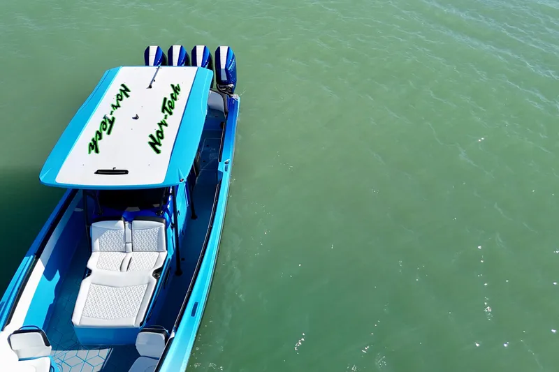Slide: The Image of 2026 Nor-Tech 390 Sport Center Console boat on calm green water. - 19