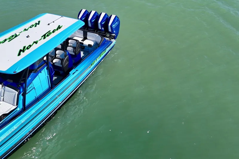 Slide: The Image of 2026 Nor-Tech 390 Sport Center Console boat on calm green water. - 20