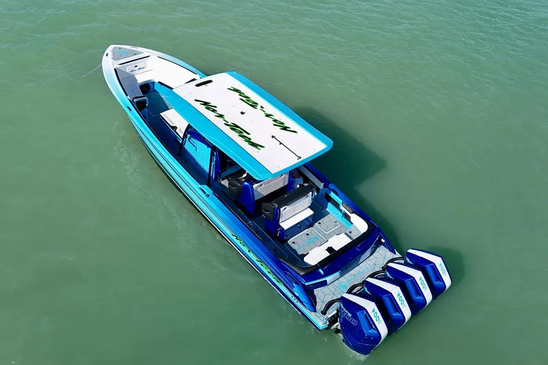 Slide: The Image of 2026 Nor-Tech 390 Sport Center Console boat with vibrant blue design and four powerful engines. - 25