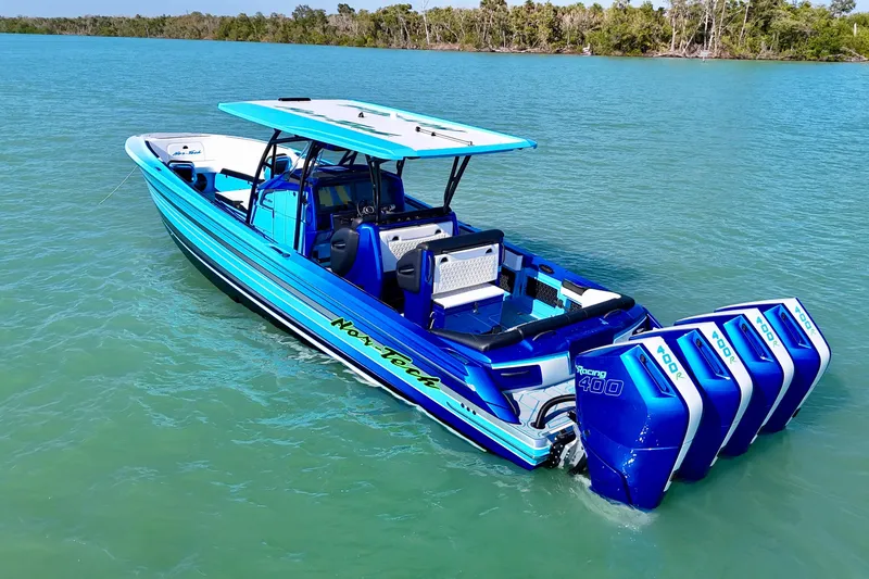 Slide: The Image of 2026 Nor-Tech 390 Sport Center Console boat with quad engines on turquoise water. - 27