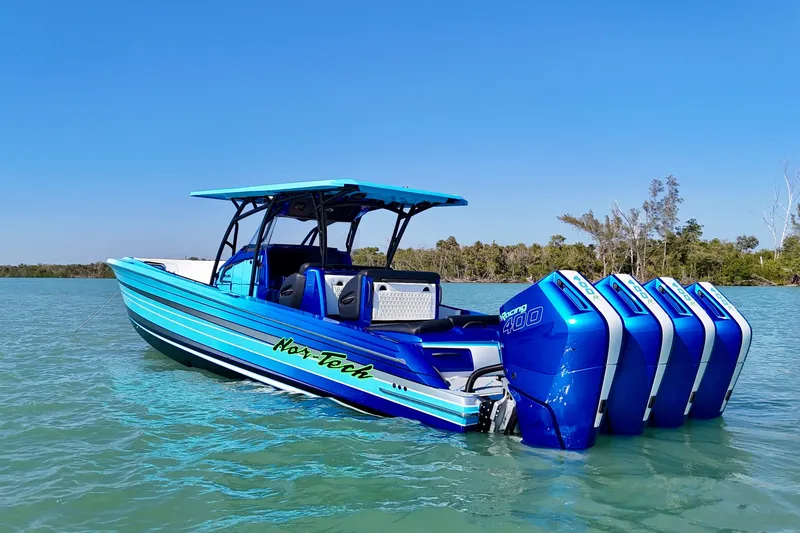 Slide: The Image of 2026 Nor-Tech 390 Sport Center Console boat with vibrant blue design and powerful engines. - 28