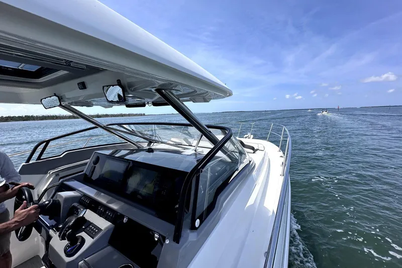 Slide: The Image of 2022 Jeanneau Leader 12.5 WA cruising on open water under clear blue skies. - 13