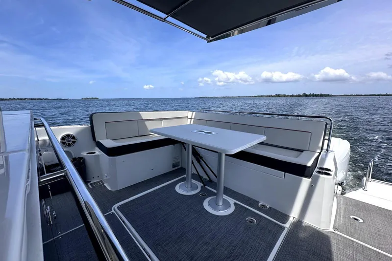 Slide: The Image of 2022 Jeanneau Leader 12.5 WA boat deck with seating and table, overlooking the ocean. - 15