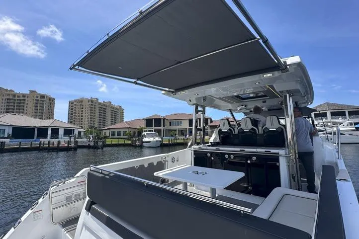 Slide: The Image of 2022 Jeanneau Leader 12.5 WA boat docked, featuring spacious seating and modern design. - 18