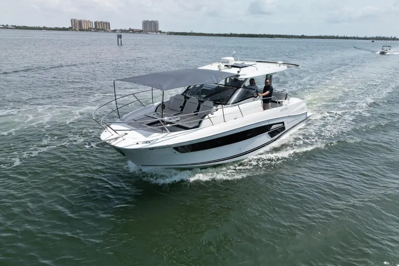 Slide: The Image of 2022 Jeanneau Leader 12.5 WA cruising on open water, showcasing sleek design and modern features. - 2