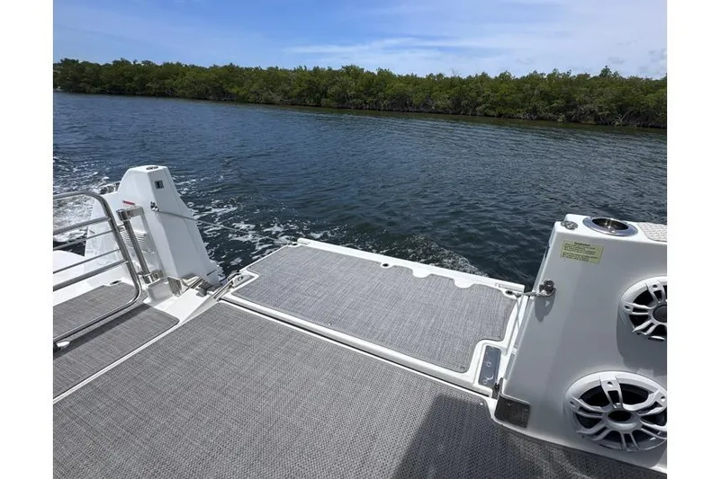 Slide: The Image of Jeanneau Leader 12.5 WA 2022 boat deck overlooking serene water and lush greenery. - 23