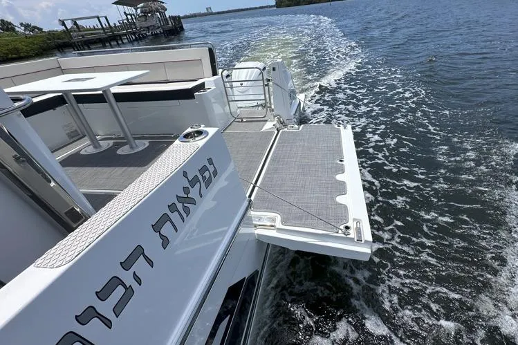 Slide: The Image of 2022 Jeanneau Leader 12.5 WA cruising on water with open deck and seating area. - 24