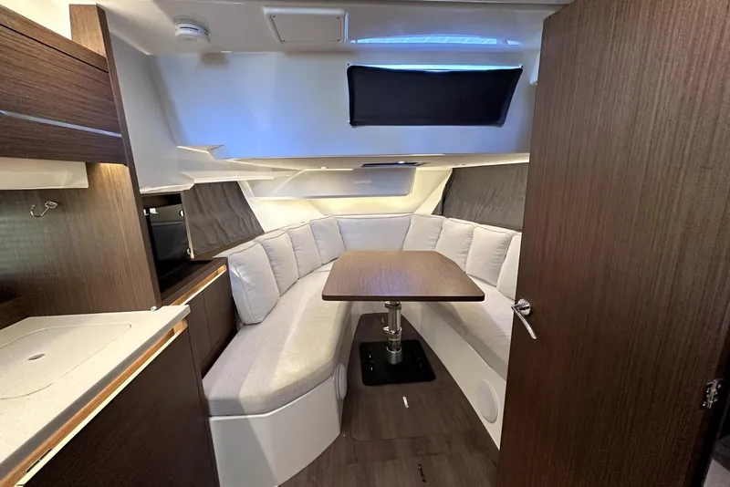 Slide: The Image of Interior of 2022 Jeanneau Leader 12.5 WA boat with cozy seating and table. - 28