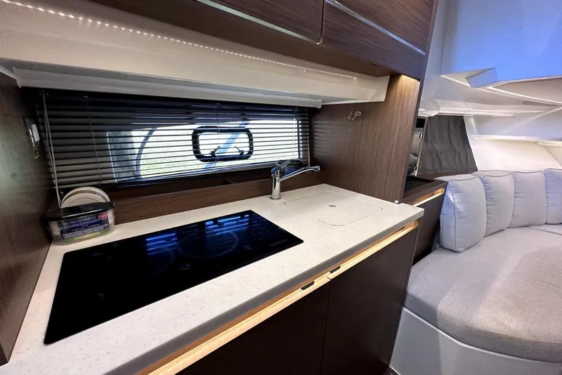Slide: The Image of Interior of 2022 Jeanneau Leader 12.5 WA yacht with modern kitchen and seating area. - 29