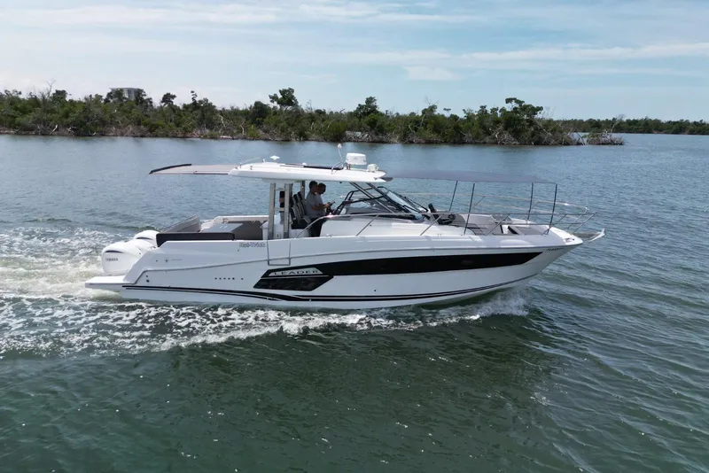 Slide: The Image of 2022 Jeanneau Leader 12.5 WA cruising on a serene lake with lush greenery. - 3