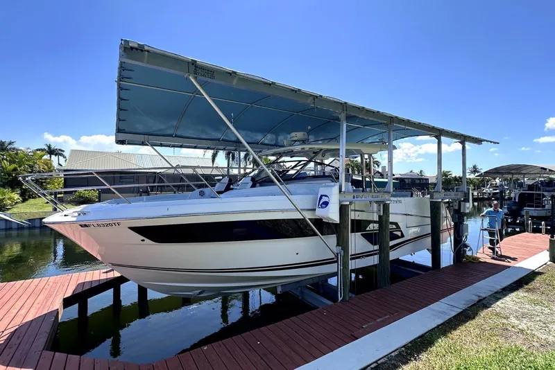 Slide: The Image of 2022 Jeanneau Leader 12.5 WA boat docked under a canopy in a sunny marina. - 40