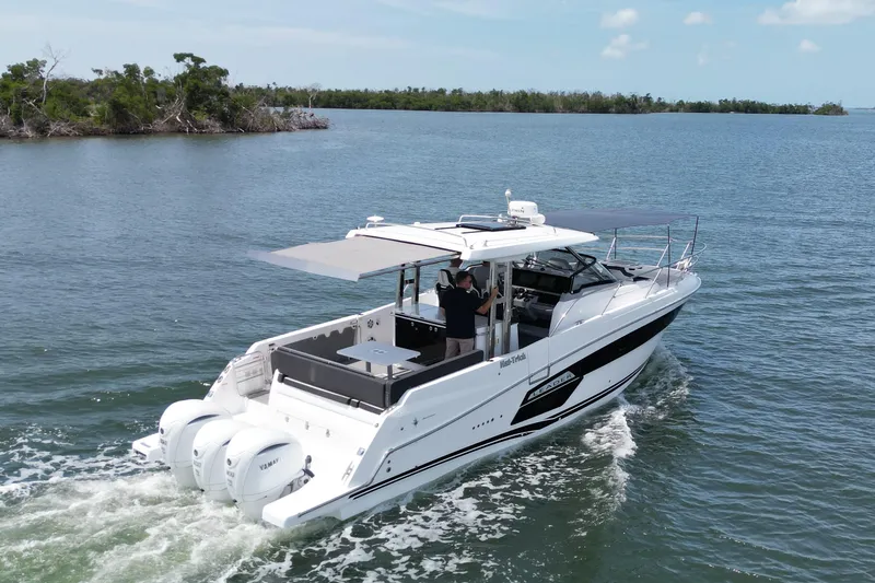 Slide: The Image of 2022 Jeanneau Leader 12.5 WA cruising on a serene lake with lush greenery. - 43