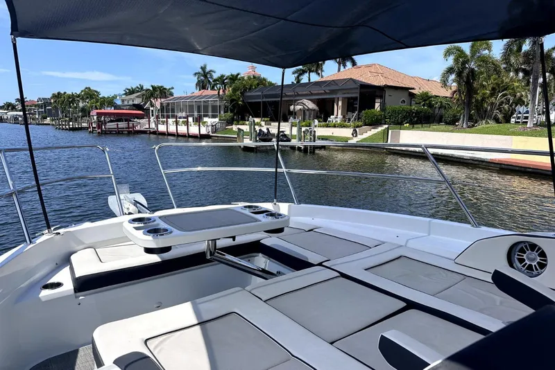 Slide: The Image of 2022 Jeanneau Leader 12.5 WA boat with spacious deck, docked near waterfront homes. - 9