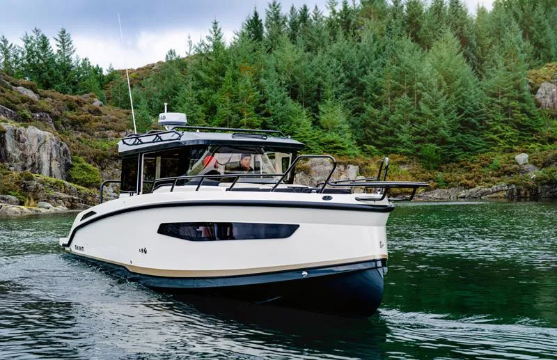 Slide: The Image of Navan C30 2025 boat cruising in a scenic forested waterway. - 2