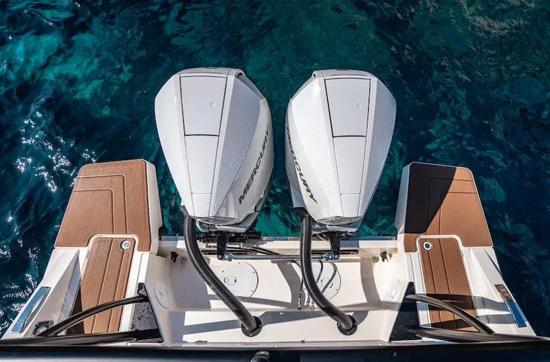 Slide: The Image of Twin outboard motors on a 2025 Navan C30 boat, viewed from above, in clear blue water. - 23