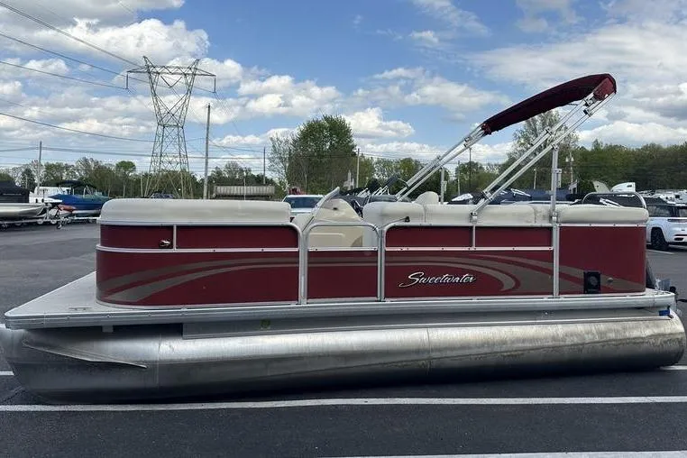 Slide: The Image of 2014 Godfrey Sweetwater 2086 C pontoon boat with red exterior, parked outdoors. - 1
