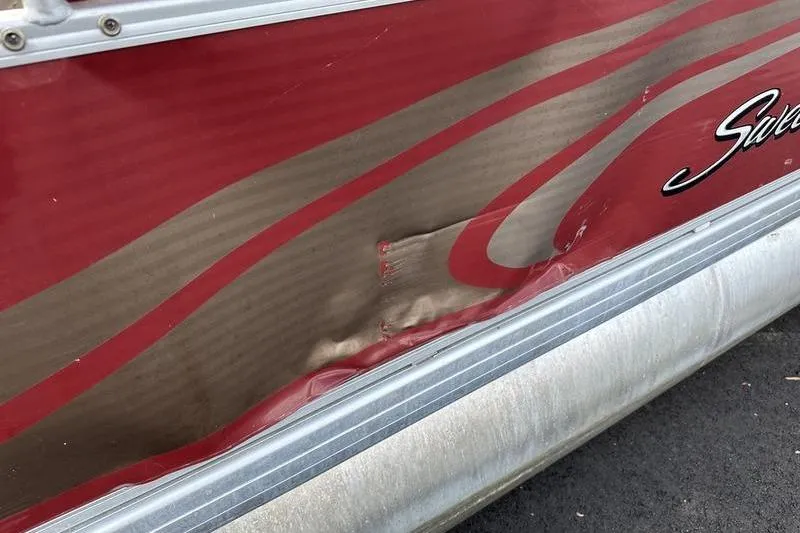 Slide: The Image of 2014 Godfrey Sweetwater 2086 C pontoon boat with visible side dent and red design. - 19