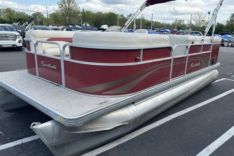 Slide: The Image of 2014 Godfrey Sweetwater 2086 C pontoon boat in parking lot, red and white design. - 2
